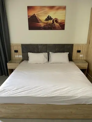 a bedroom with a large bed with white sheets at Seafront Hotel Apartment with private beach in Hurghada