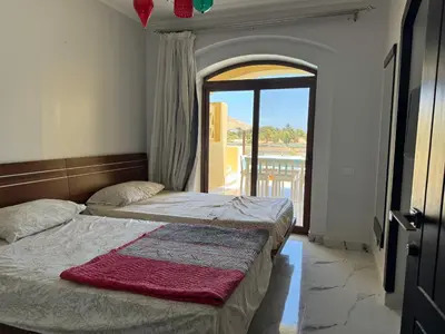 two beds in a room with an open door at NEXT STAY, 3BR Villa, El Gouna in Hurghada