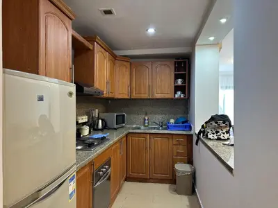 a kitchen with wooden cabinets and a white refrigerator at Panoramic Sea View in Hurghada