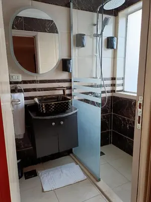 a bathroom with a shower and a sink and a mirror at FayedBasmadahabiya in Luxor