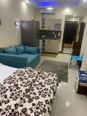 a living room with a blue couch and a kitchen at Sea View Apartment Cecelia Resort in Hurghada