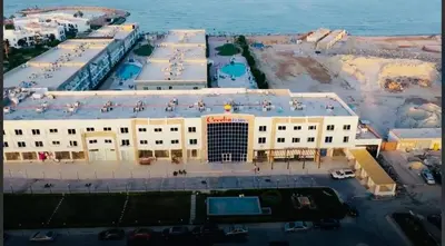 a large white building next to the ocean at Sea View Apartment Cecelia Resort in Hurghada