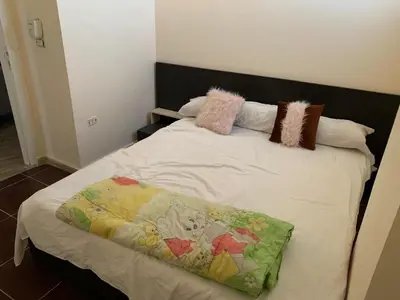 a bed with pillows and a blanket on it at Downtown Studio in Hurghada