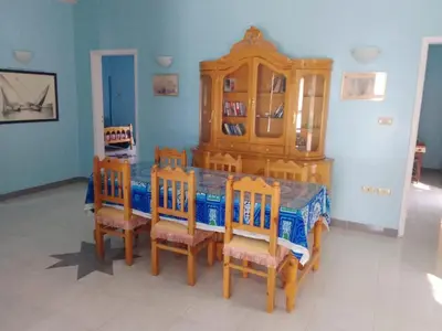 a dining room with a wooden table and chairs at Memnon Apartments in Luxor