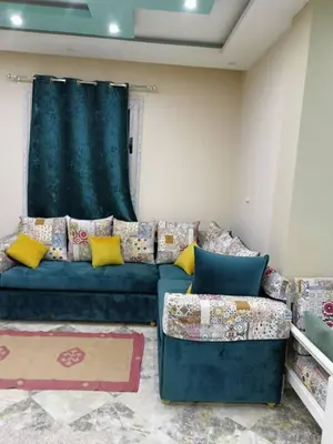 a living room with a blue couch with yellow pillows at Magyipt in Hurghada