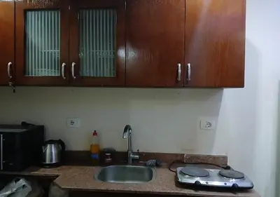 a kitchen counter with a sink and wooden cabinets at Luxury Cecelia resort in Hurghada