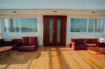 a living room with two couches and a wooden floor at Azhar Dahabiya luxury suites in Esna