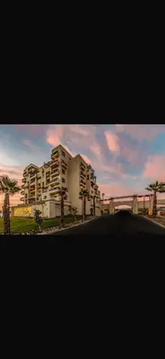 a view of a building with palm trees and a street at Hurghada in Hurghada