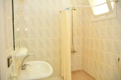 a bathroom with a shower and a toilet and a sink at Apartment Empire Hotel in Hurghada