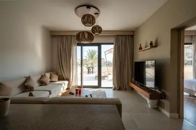 a living room with a couch and a tv at Elegant Fanadir Marina 2BR • Ground Floor in Hurghada