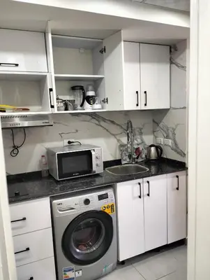 a kitchen with a washing machine and a microwave at Scandic Resort Hurghada in Hurghada