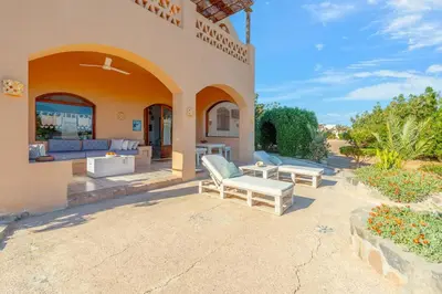an outdoor patio of a house with a couch at Rihanna apartment direct to the sea in Hurghada
