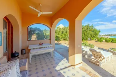 an open patio with a bench and a table at Rihanna apartment direct to the sea in Hurghada