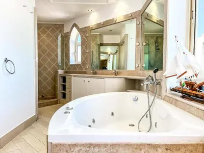 a large bathroom with a tub and a large mirror at Beachfront Apartment Somabay in Hurghada