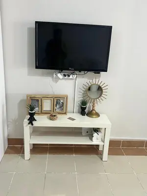 a tv on a wall with a white table with a tv at Studio sea view in Hurghada