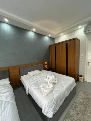a bedroom with two beds with white sheets and towels at Luxury serviced apartments in Hurghada