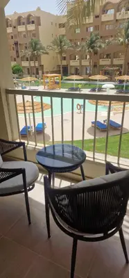 a balcony with chairs and a table and a pool at Blue Dream in Hurghada