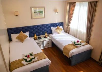 a hotel room with two beds with flowers on them at دهبيه كوين شارلوت in Luxor