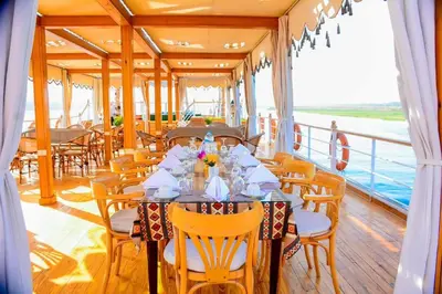 a dining room on a cruise ship with a table and chairs at دهبيه كوين شارلوت in Luxor