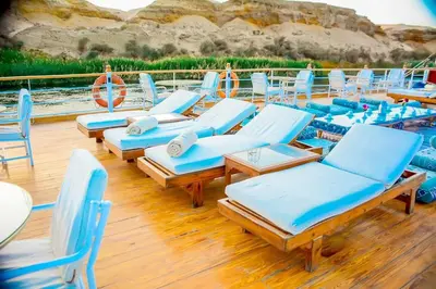 a bunch of lounge chairs and tables on a boat at دهبيه كوين شارلوت in Luxor
