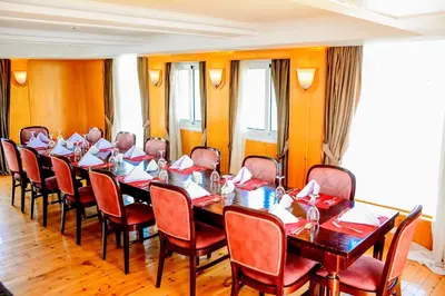 a meeting room with a long table and chairs at دهبيه كوين شارلوت in Luxor