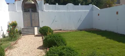 a small white house with a door and a yard at Villa Saeed in Al Karnak