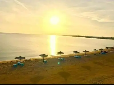 a group of umbrellas on a beach with the ocean at Cecelia Resort - Studio chalet in Hurghada