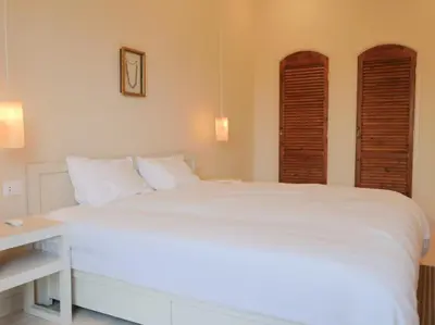 a bedroom with a large white bed with a desk at Boutique hotel Neferu Stay in Luxor