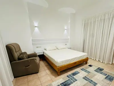 a bedroom with a bed and a chair at Enjoy a peaceful stay in Hurghada