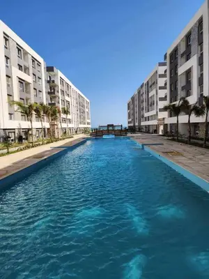 a large pool of blue water in front of buildings at Fanadir Bay Apartments in Hurghada