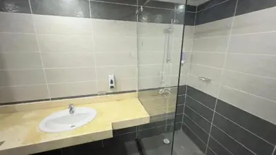 a bathroom with a sink and a glass shower at Fanadir Bay Apartments in Hurghada