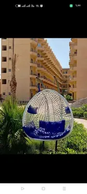 a blue chair sitting in front of a building at Hurghada Apartment sea view Fiesta 209 in Hurghada