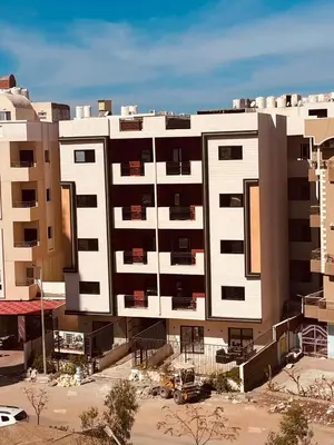 a large white building in front of some buildings at مبارك 5 in Hurghada