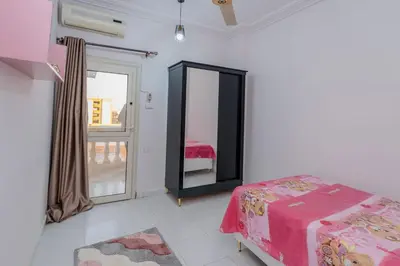 a bedroom with a bed and a mirror and a window at Madares sweet home appartment in Hurghada