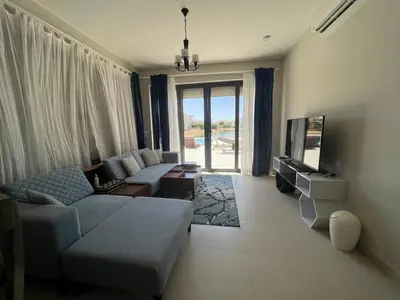 a living room with a couch and a tv at Tawila 3BR Family Townhouse • Lagoon Retreat Villa in Hurghada