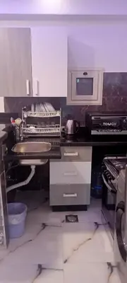 a kitchen with a sink and a microwave at شقه للايجار غرفه وصاله ومطبخ وحمام بالهضبه الغردقه in Hurghada