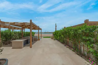a boardwalk with a bench and a pergola at Charming Jungle Home in Hurghada
