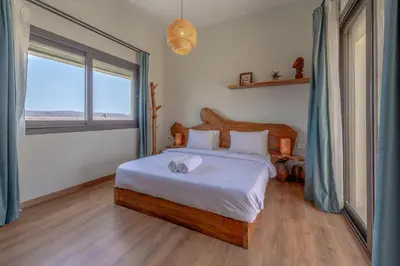 a bedroom with a bed and a large window at Charming Jungle Home in Hurghada