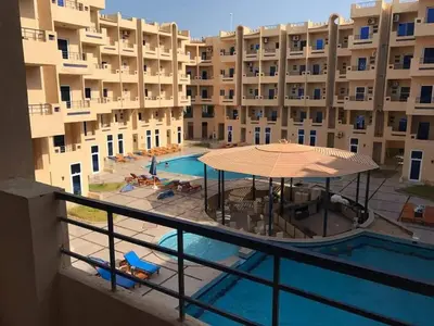 a view of the pool from the balcony of a building at Sun and fun Hurgadah Apartments in Hurghada