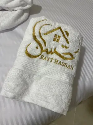 a towel with the name of aay hazan on a bed at Bayt Hassan S10 - Fabulous one bedroom apartment in Hurghada