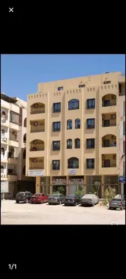 a large building with cars parked in front of it at Bayt Hassan S10 - Fabulous one bedroom apartment in Hurghada