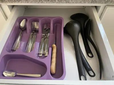 a purple tray with utensils in a drawer at Bayt Hassan S6 - Cosy 1 bedroom apartment in Hurghada