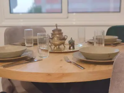 a wooden table with plates and bowls and glasses at Arabic Apartment in Hurghada