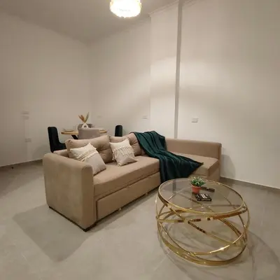 a living room with a couch and a glass table at Boho Apartment in Hurghada