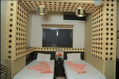 a room with two beds with pink towels on them at El Massa in Idfu