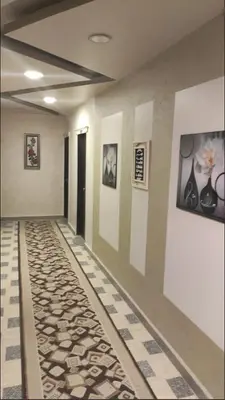 a hallway with a tile floor and paintings on the walls at El Massa in Idfu