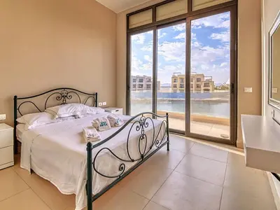a bedroom with a bed and a large window at El Gouna Villa in Tawila with private pool in Hurghada
