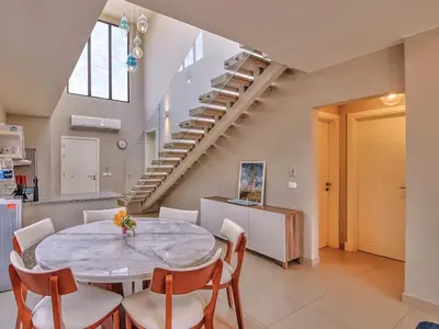 a dining room with a table and chairs and stairs at El Gouna Villa in Tawila with private pool in Hurghada
