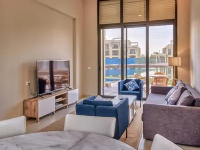 a living room with a tv and a couch and chairs at El Gouna Villa in Tawila with private pool in Hurghada