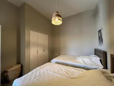 a bedroom with two beds and a chandelier at Tawila Luxury 2BR Skyline Loft • Rooftop in Hurghada